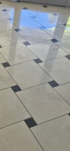 Fényes járólap felületén oldalirányú fényben látható csíkok és fátyolos padlónyomok